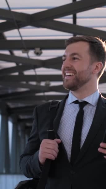 一个穿正装的男人 包括一件连衣裙 领带和一件夹克 笑着高兴地拿着一个手提箱 — 图库视频影像
