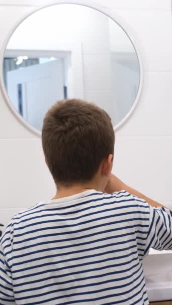 Mladý Chlapec Používá Rukáv Aby Vyčistil Zuby Před Kruhovým Zrcadlem — Stock video