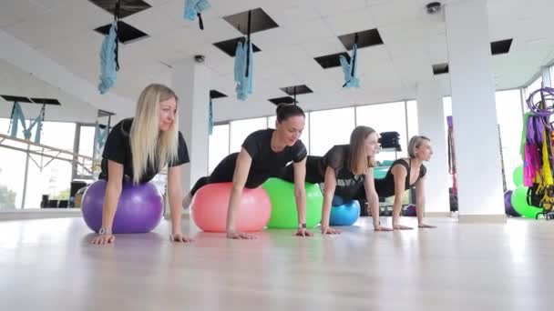 一群女人在一个休闲活动中玩得很开心 她们在体育馆里做普拉提球的俯卧撑 — 图库视频影像