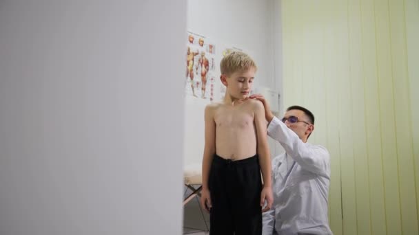 整形外科医は少年の背中を診察する 子供たちの治療 子どもの医師 — ストック動画