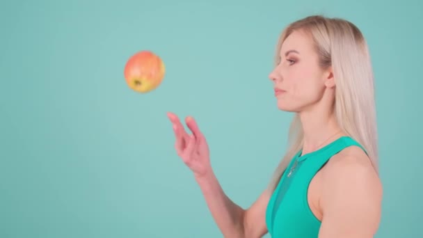 一个女人在手指上摆弄着一个苹果 表现出一种快乐的姿势 就像在一场有趣的表演艺术活动中的娱乐活动 — 图库视频影像