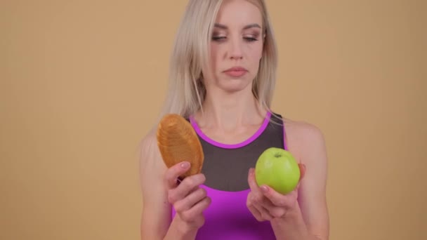 Szczęśliwa Blondynka Trzymająca Ciasteczko Jabłko Pokazująca Naturalne Jedzenie Gestem Palców — Wideo stockowe
