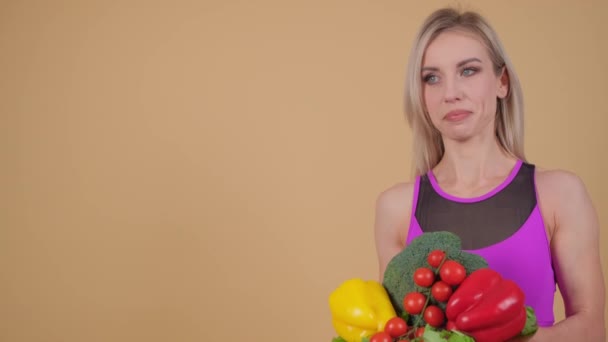 一个快乐的女人一边拿着一束蔬菜一边欢快地做手势 — 图库视频影像