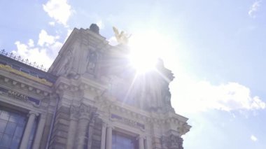 Güneş ışınları bulutlarla dolu gökyüzüne nüfuz ediyor, hareketli şehirde binaları aydınlatıyor, pitoresk bir manzara yaratıyor..