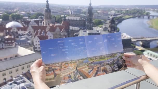 Person Står Foran Holder Kart Beundrer Byens Design Landskap Bygninger – stockvideo