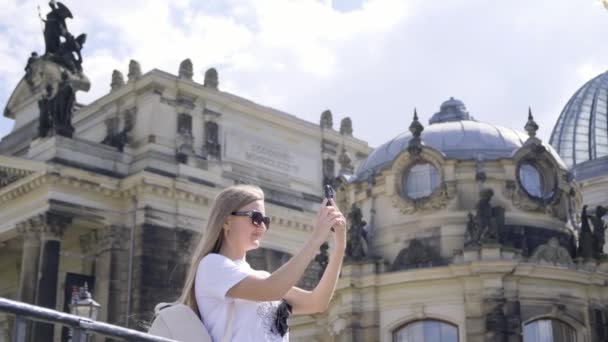 Μια Γυναίκα Φωτογραφίζει Ένα Μεσαιωνικό Κτίριο Αρχιτεκτονικής Ενάντια Στο Γραφικό — Αρχείο Βίντεο