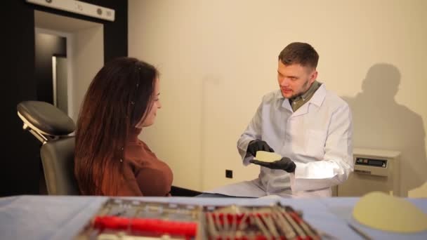 在美容院会诊期间 医生为女性植入硅胶 一位妇女与一位整形外科医生讨论隆胸问题 — 图库视频影像