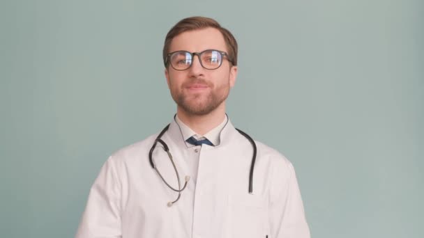 医者は 眼鏡と首の周りのステスコープで ドレスシャツとフレンドリーな笑顔を着ています — ストック動画