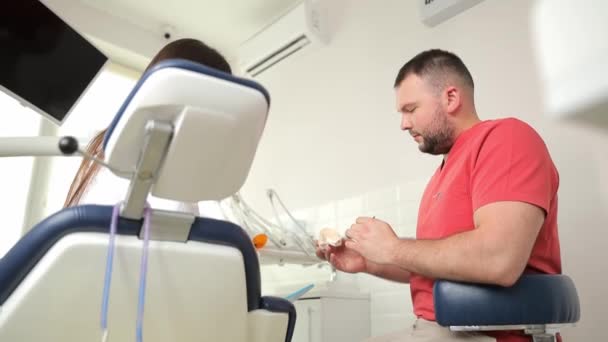 Man Dental Chair Converses Patient While Arm Gestures Used Food — Stock Video
