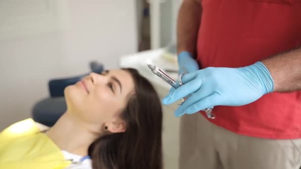 Eine Frau Liegt Einem Zahnarztstuhl Während Der Zahnarzt Eine Spritze — Stockvideo