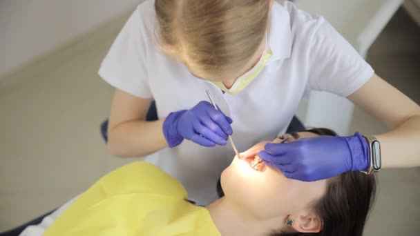 의사는 사무실에서 손가락을 사용하여 환자의 치아를 검사하는 검사를 수행하고 있습니다 — 비디오