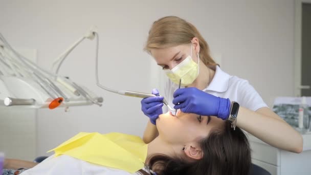 女性は歯科検査を受けています 歯科医は歯科オフィスで彼女の歯を調べます — ストック動画