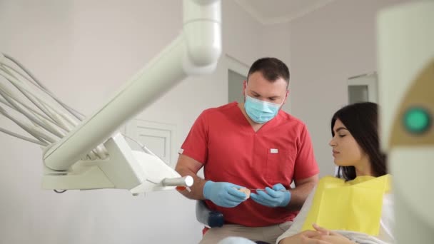 歯科医は歯科オフィスで女性の歯の状態を評価し 歯の健康を確保しています — ストック動画