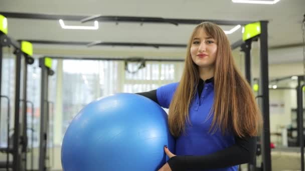 在健身房里 一个女人拿着一个蓝色的电动运动球 用来瞄准她的腰部 大腿和腹部 同时改善她的胸部和躯干肌肉 — 图库视频影像
