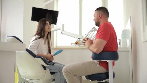 Man Sitter Tandstol Tandläkarmottagning Och Pratar Med Kvinna — Stockvideo