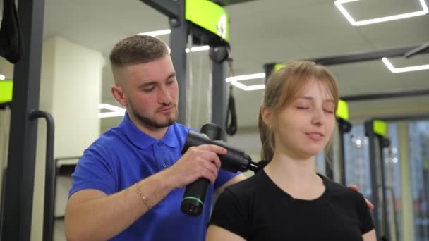 Mężczyzna Oferuje Relaksujący Masaż Kobiecie Siłowni Celując Jej Stawy Ramiona — Wideo stockowe