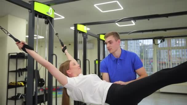 一个男人正在健身房里帮助一个女人 做运动来锻炼身体和锻炼身体 — 图库视频影像