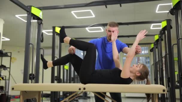 Man Assisting Woman Exercises Using Sports Equipment Gym Table Improve — Stock Video