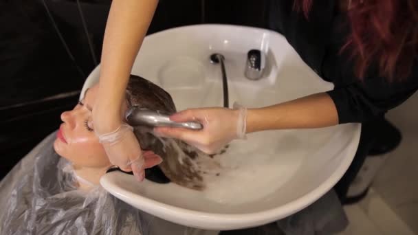 漂亮可爱的年轻女子喜欢按摩头 而专业理发师则用洗发水洗头 护发产品 — 图库视频影像
