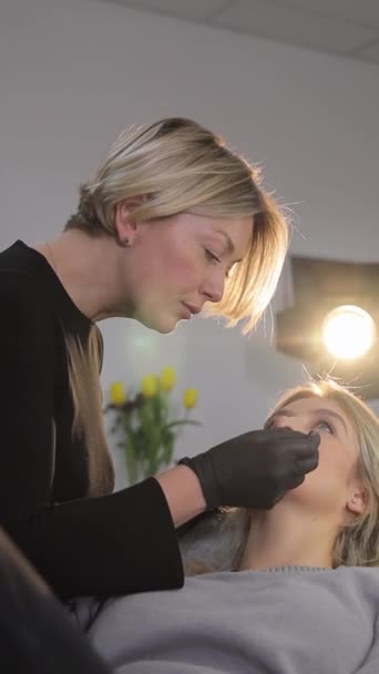 Uma Mulher Está Usando Mão Para Aplicar Maquiagem Outro Rosto — Vídeo de Stock
