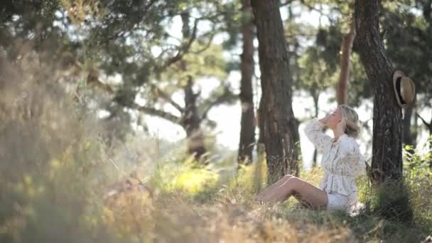 Kobieta Relaksuje Się Pod Wysokim Drzewem Pośród Spokojnego Naturalnego Krajobrazu — Wideo stockowe