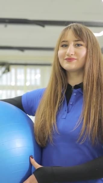 一个可爱的年轻治疗师女孩拿着一个大体操球的特写 工作中的女性康复者 — 图库视频影像