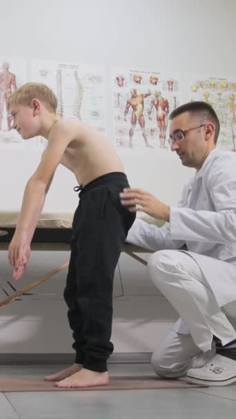 Ljushårig Pojke Ett Ortopedistmöte Ett Läkarmottagning Professionell Ortoped Undersöker Ett — Stockvideo