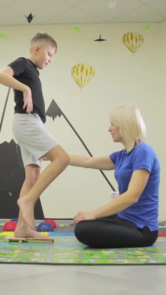 在一家受伤康复中心为一个年轻人做腿运动 儿童的生活概念 — 图库视频影像
