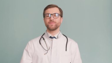 Doktor, gözlüklü ve boynunda steteskop olan, bir gömlek ve dostane bir gülümseme takıyor..
