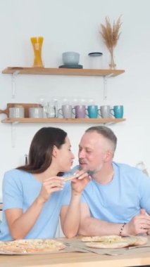 Mutlu bir çift lezzetli bir pizzayı paylaşıyor. Ağızları sulanırken her ısırığın tadını çıkarıyorlar..