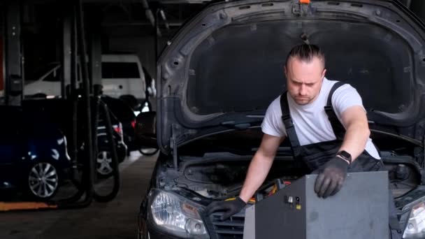 Egy Férfi Megjavít Egy Autót Egy Garázsban Nyitott Motorháztetővel Jármű — Stock videók
