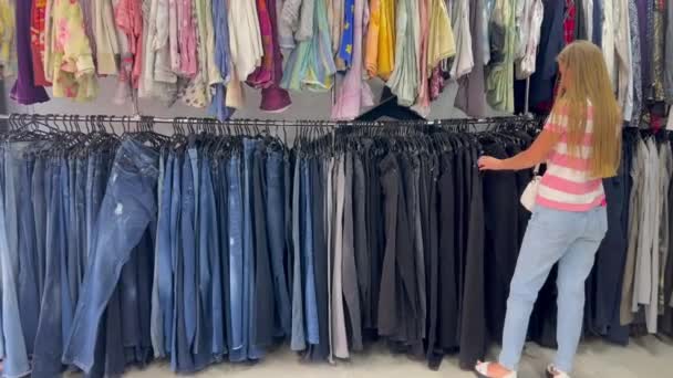 Женщина Просматривает Джинсы Магазине Одежды Исследует Воду Ногу Талию — стоковое видео