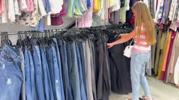 Eine Frau Stöbert Sportbekleidungsregalen Untersucht Jeans Shirts Und Kleiderbügel Einem — Stockvideo