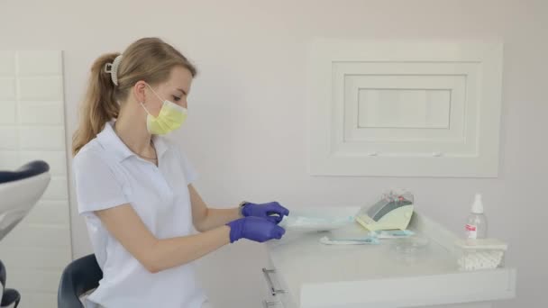Kobieta Rękawiczkach Masce Siedzi Przy Stole Dentystycznym Gotowa Służby Pokazując — Wideo stockowe