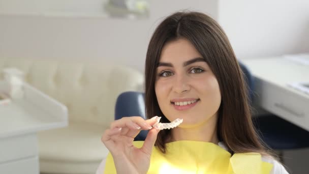 Una Donna Con Sorriso Felice Siede Una Sedia Dentale Tenendo — Video Stock