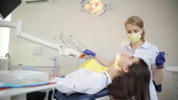 一位妇女正在一个房间里接受牙科服务 牙医在她坐在椅子上检查她的牙齿 — 图库视频影像