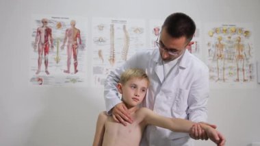 Pediatrik ortopedist klinikte bir çocuğu muayene ediyor. Skolyoz tedavisi. Tıp kavramı.