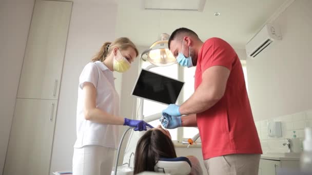 Ein Zahnarzt Und Eine Krankenschwester Inspizieren Die Zähne Eines Patienten — Stockvideo