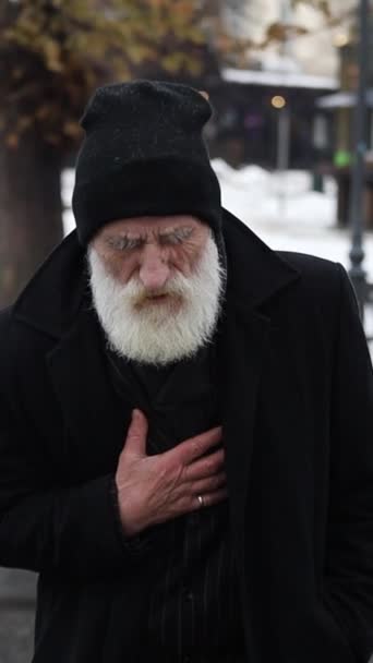 老年男子身穿黑色外套站在外面 胸部疼痛或心脏病发作的垂直录像 冬天的中风 保健概念 — 图库视频影像
