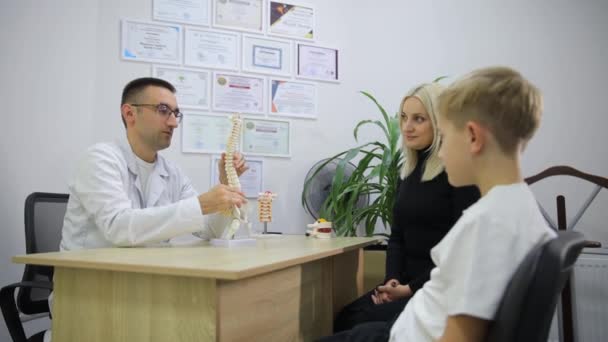 Γιατρός Κρατώντας Ένα Μοντέλο Γόνατος Έχει Μια Συνομιλία Ένα Νεαρό — Αρχείο Βίντεο