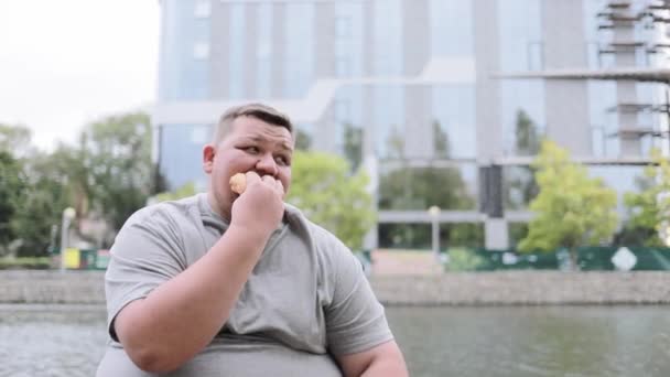 Портрет Человека Избыточным Весом Сидящего Снаружи Поедающего Булочку Пьющего Воду — стоковое видео