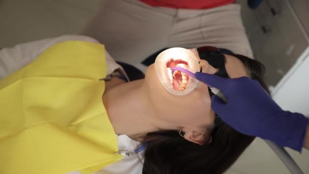 女性は歯医者によって検査され 笑顔で親指のジェスチャーを使用しています — ストック動画