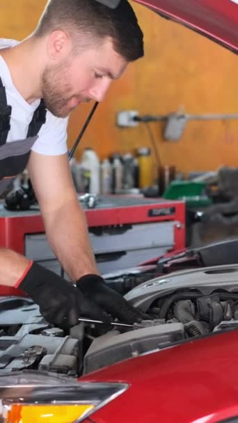 Bir Adam Garajda Motorlu Taşıtların Motorunu Tamir Ediyor Kırmızı Arabalar — Stok video