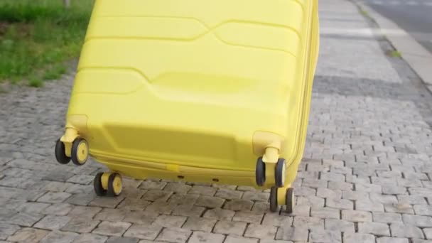 Zbliżenie Żółtej Walizki Jadącej Brukowcach Mieście Podróżuje Walizką Podróżowanie Bagażem — Wideo stockowe