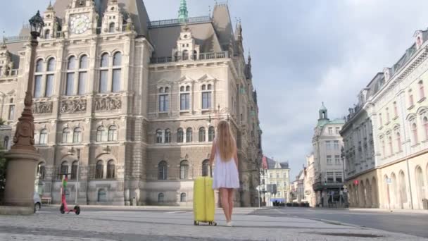 Hátsó Kilátás Egy Fiatal Lányra Egy Bőrönddel Aki Óvárosban Sétál — Stock videók