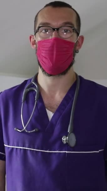 Homem Com Uma Bata Roxa Uma Máscara Vermelha Usando Estetoscópio — Vídeo de Stock