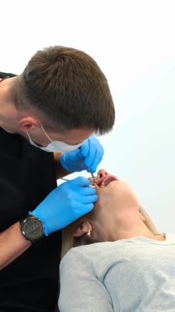 Dentysta Nosi Osobisty Sprzęt Ochronny Hełm Podczas Badania Zębów Kobiet — Wideo stockowe