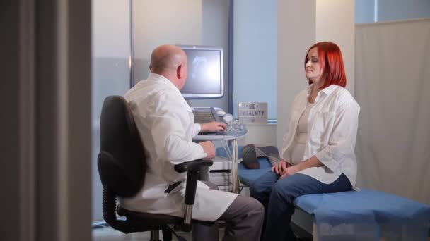 婦人科医がオフィスで妊娠している患者と話している — ストック動画