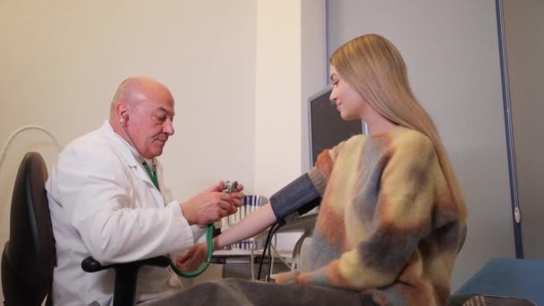 専門的に若い女性の健康を監視する男性医師は 高血圧を発見しました — ストック動画