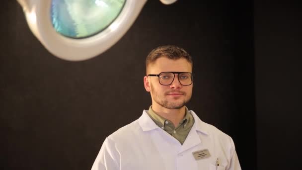 Porträt Eines Hübschen Jungen Arztes Uniform Der Auf Schwarzem Hintergrund — Stockvideo